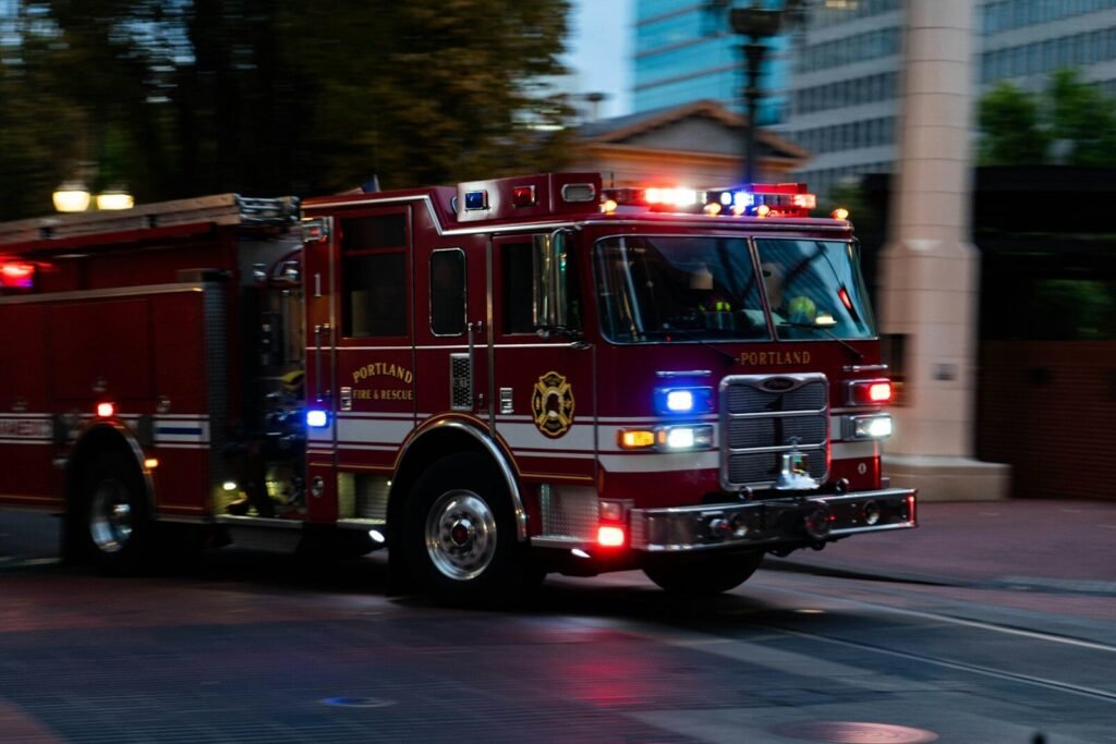 a fire truck driving down a street next to tall buildings