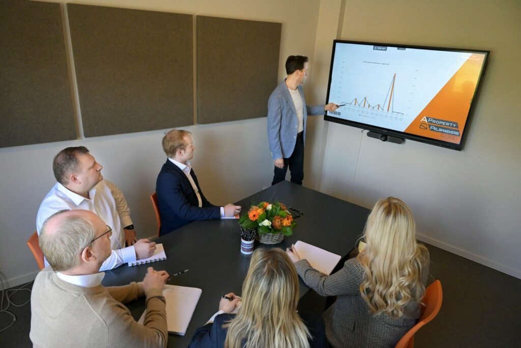 A man presents a graph to colleagues in a meeting